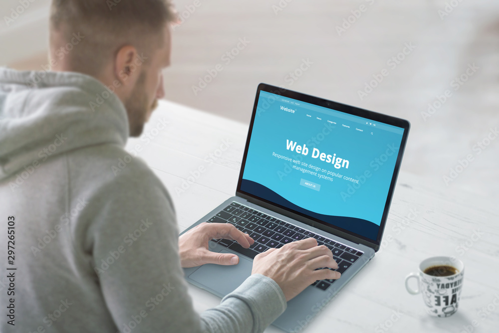 Poster web designer works on a promo website concept. office desk, close-up. flat design web site on laptop