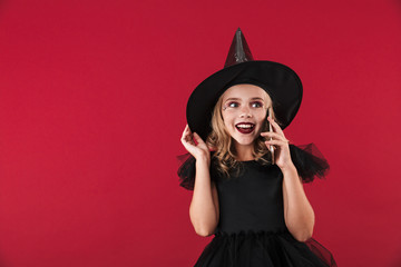 Pleased little girl witch in carnival halloween costume