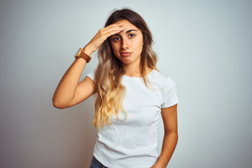 Fototapeta premium Young beautiful woman wearing casual white t-shirt over isolated background worried and stressed about a problem with hand on forehead, nervous and anxious for crisis