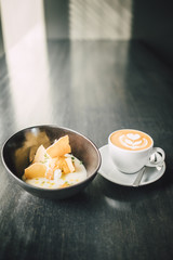 Delicious Vanilla dessert with cup of coffee on dark table