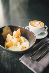 Delicious Vanilla dessert with cup of coffee on dark table
