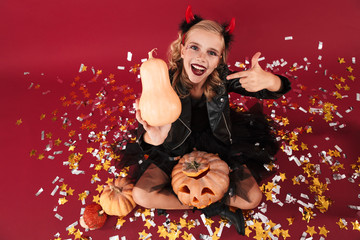 Obraz na płótnie Canvas Emotional optimistic little girl devil in carnival costume