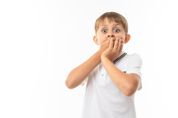 A little boy in a white shirt, blue shorts with blonde hair, white t-shirt shows that he is scared