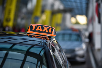 orange taxi sign on black vip car in airport