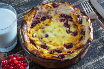 Sweet cottage cheese casserole with gooseberry and semolina on wooden table. Ceramic bowl with baked cottage cheese casserole