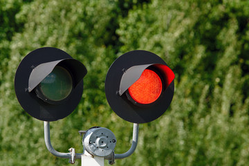 Traffic light with flashing red signal on railway. Red light at a railway level crossing. Warns of...