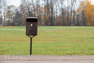 Trash bin in public park. Pedestrian and bicycle paths