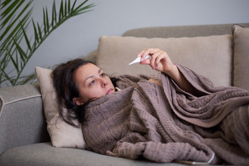 Ill upset woman blowing running nose got flu caught cold sneezing in tissue sit on sofa, sick...