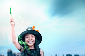 Asian witch little girl using the wand with a magic shine