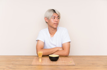 Young asian man with matcha tea in a table thinking an idea