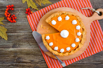 Traditional homemade pumpkin pie on a wooden table. Healthy food, dessert for gourmets. Thanksgiving theme. Traditional autumn baking. Top view.