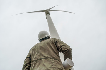 engineer examines the place with a plan in his hands. Project Manager at the wind farm. photo from the back