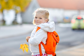 Cute little adorable toddler girl on her first day going to playschool. Healthy happy baby walking...