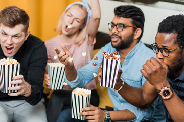 Group of friends watching television at home together
