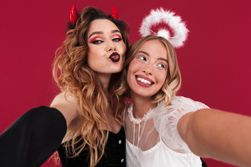 Women angel and demon in carnival costumes