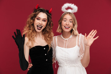 Demon and angel in carnival costumes isolated