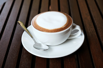 Hot cappuccino with cold water on a wooden table