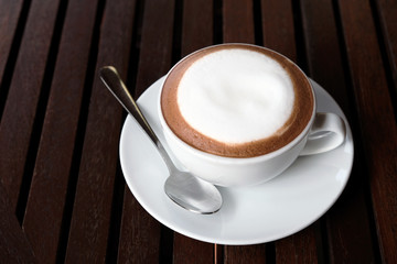 Hot cappuccino with cold water on a wooden table