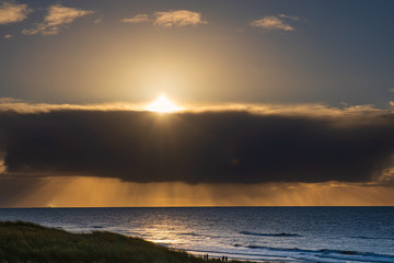 Sonnenuntergang bei bewölktem Himmel über der Nordsee bei Egmond aan Zee/NL