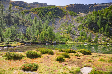 Obraz premium Panoramic view of a mountain lake on a sunny autumn day.