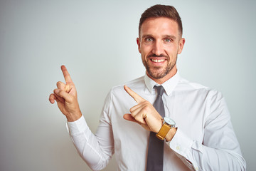 Young handsome business man wearing elegant white shirt over isolated background smiling and looking at the camera pointing with two hands and fingers to the side.