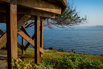 wooden porch facing a lake on a sunny day