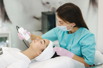 Obraz na płótnie Canvas Young woman taking beauty procedure in spa salon