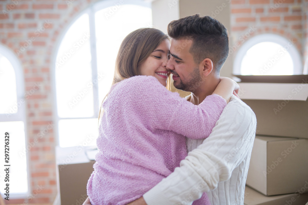 Poster Young beautiful couple hugging in love celebrating very happy moving to new apartment