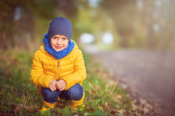 Happy child boy playing outside in autumn