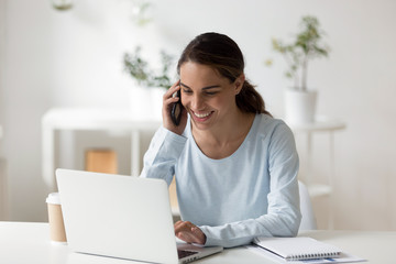 Young happy mixed race freelancer talking on smartphone with client.