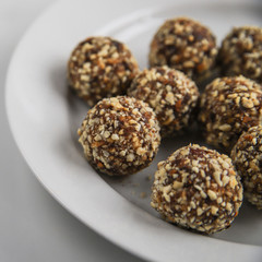 Energy balls – homemade healthy dessert cooked with dates, nuts, dry fruits and cocoa. Organic dry fruits snacks on marble background