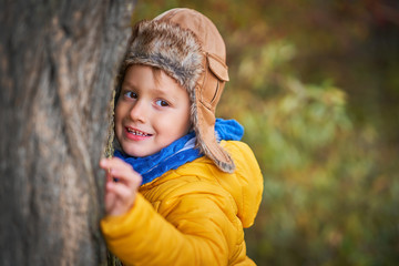 Happy child boy playing outside in autumn