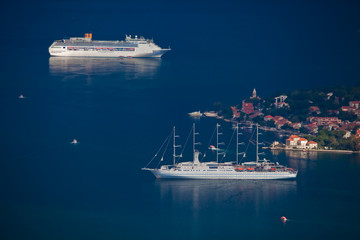 Beautiful cruise ships are far below among the dark blue near the town with red roofs, Montenegro Kotor