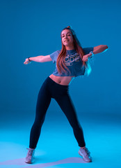 Young stylish girl dancing zumba in the Studio on a colored neon background. Dance poster design.