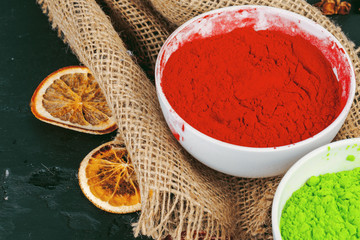 Traditional Indian Holi colours powder, spices on dark rustic background