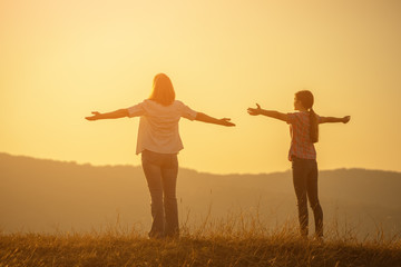 Happy grandmother and granddaughter enjoying sunset.