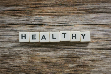 Word Healthy alphabet on wooden background.