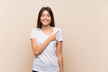 Fototapeta premium Pretty young girl over isolated background pointing to the side to present a product