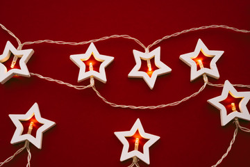 Fototapeta na wymiar Illuminated star shaped garland on color background close up