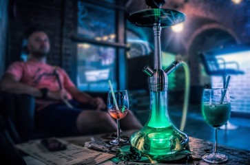 Budapest, Hungary - August 29, 2019: Tall chairs near the bar and a hookah on the table. Cafe interior in the old basement of a house in Budapest. Nightlife and entertainment in the capital of Hungary - obrazy, fototapety, plakaty