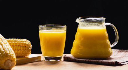 Corn milk in jug and glass on black background with morning light in  kitchen, Warm drinks make good healthy,Prevent eye disease, High in fiber, Many vitamins and anti-cancer agents, Made from maize.