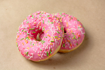 Two pink donut on brown paper