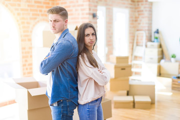 Beautiful young couple moving to a new house skeptic and nervous, disapproving expression on face with crossed arms. Negative person.