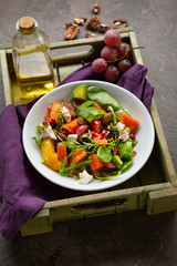 Seasonal salad with orange and pumpkin in bowl