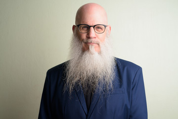 Face of mature bearded bald businessman in suit wearing eyeglasses - obrazy, fototapety, plakaty