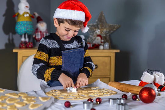 Cute child making cookies with shapes on Christmas Day