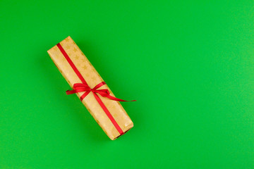Decorated gift box on a green background, flat lay top view