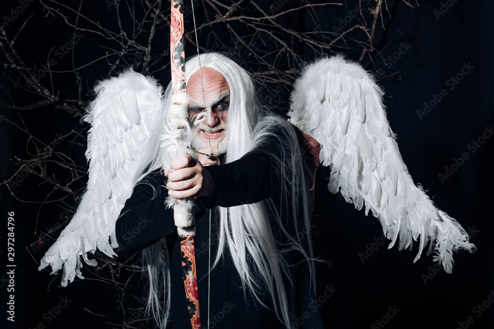 Wall mural Art photo of a Angelic man. Senior man posing with angel wings. Evil vampire man. Man wizard with fantastic make up on demon face. Druid on black background. - Wall murals