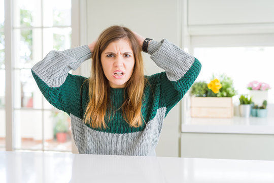 Young beautiful plus size woman wearing casual striped sweater Crazy and scared with hands on head, afraid and surprised of shock with open mouth