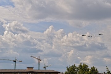 flying combat helicopters against a blue sky with clouds on a sunny day